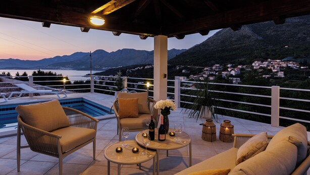 A terrace with a pool, seating, and a view of the mountains. - Apartments Villa Olea Solis (Cavtat)