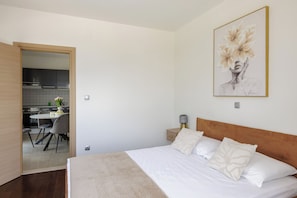 Une chambre à coucher avec un lit, une table de chevet, une lampe et un tableau au mur.