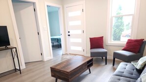 A living room with a wooden coffee table, grey sofa, and red pillows. - Beautiful 3-bedroom house in wonderful Bellingham for your getaway (Bellingham)