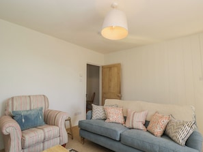 A living room with a striped armchair, a blue sofa, and patterned cushions.