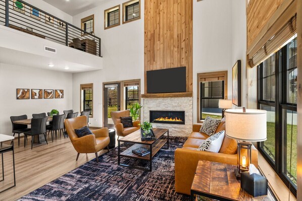 A spacious living area with a fireplace, a dining table, and comfortable seating.