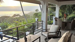 A balcony with a view of the ocean and lush greenery. - 4 Bedroom Oceanview Haven (Dominical)
