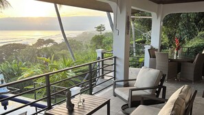 A balcony with a view of the ocean and lush greenery. - 4 Bedroom Oceanview Haven (Dominical)