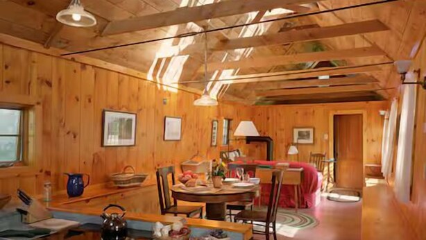 A wooden interior with a kitchen, dining area, and a cozy living space.