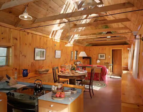 A wooden interior with a kitchen, dining area, and a cozy living space. - The Sugarhouse in Dummerston, Vermont (Dummerston)