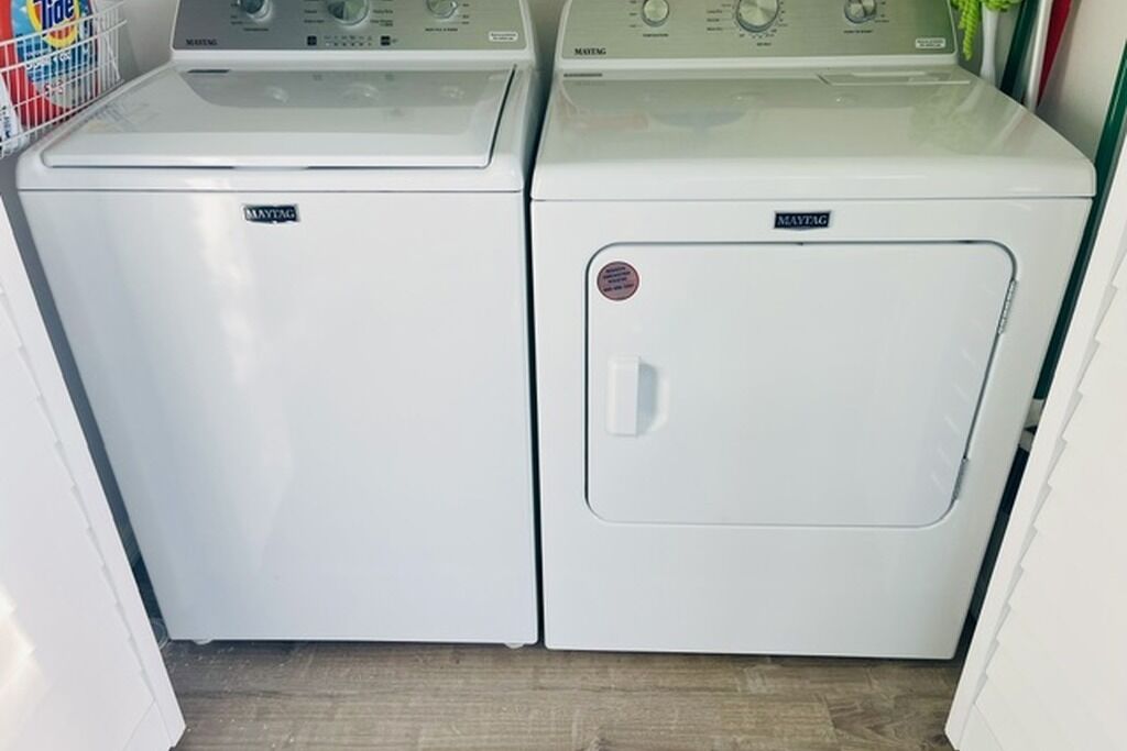 To Maytag vaskemaskiner i hvidt med betjeningspaneler.