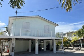A two-story building with a covered entrance and a balcony.