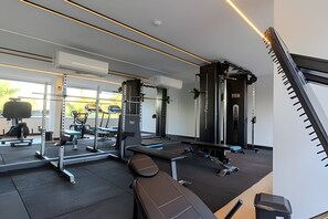 Una palestra con diverse attrezzature per esercizi, una panca e un supporto a parete.