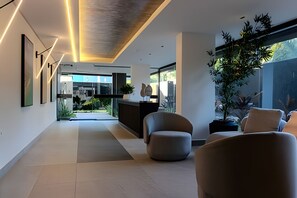 Un interno moderno con una reception, un'area salotto e ampie finestre.