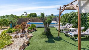 A backyard with a swimming pool, lounge chairs, and a pergola. - Villa 'Los Arcos' with Pool, Mountain Views, Wi-Fi, and Air Conditioning (Alhaurín de la Torre)