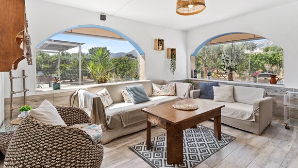 A spacious living area with a sofa set, a wooden coffee table, and a hanging light fixture. - Villa 'Los Arcos' with Pool, Mountain Views, Wi-Fi, and Air Conditioning (Alhaurín de la Torre)