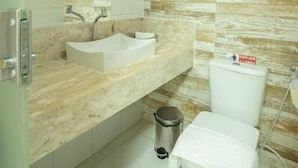A bathroom with a sink, mirror, toilet, and shower. - Pousada Manhã Dourada (Morro de São Paulo)