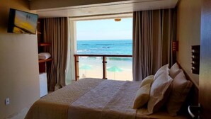 A hotel room with a bed, a TV, a view of the beach, and a balcony. - Pousada Manhã Dourada (Morro de São Paulo)