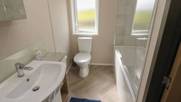 Un baño con lavamanos, inodoro y bañera.