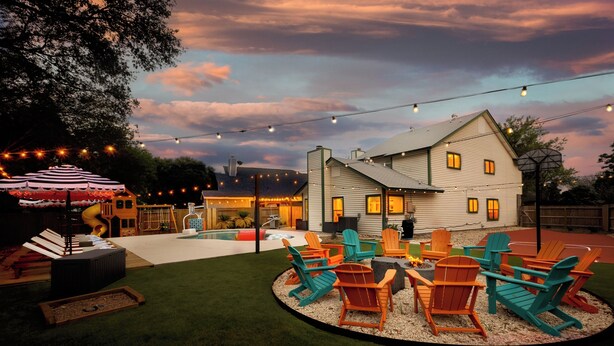 A backyard with a fire pit, outdoor seating, and string lights. - The Saddle Club • Pool • Cinema • Vibes • Arcade (San Antonio)