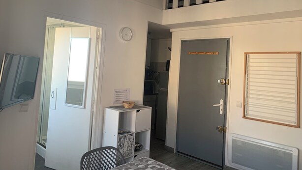 A room with a bed, a desk, a chair, a window, a door, and a radiator. - Rent studio 4 persons sea and city center (Le Grau-du-Roi)