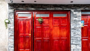 A double wooden door with a stone wall and a hanging plant. - Modern 1-bedroom studio apartment near downtown Cusco perfect for your stay (Cusco)