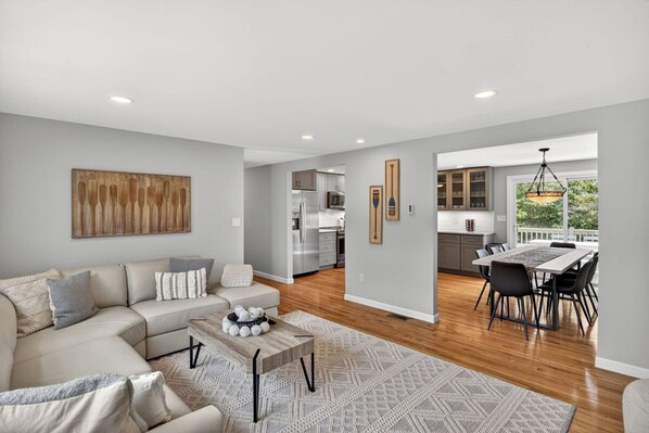 A modern living room with a sofa, coffee table, and dining area.