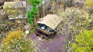 Une maison moderne dotée d’une terrasse, entourée d’arbres et bordée d’une allée en gravier.