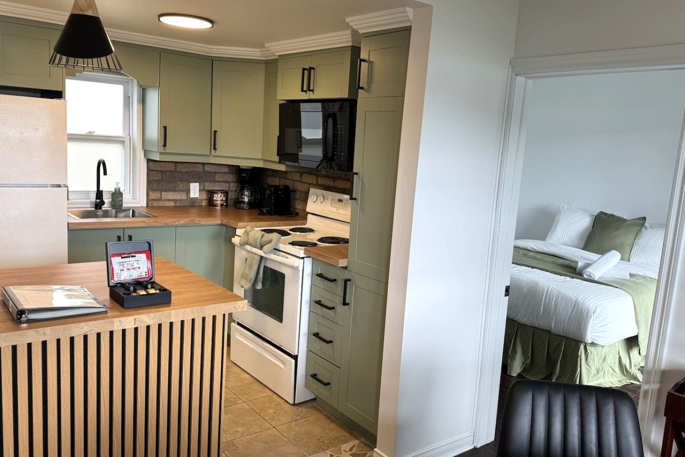 A compact kitchen with a stove, microwave, and coffee maker.