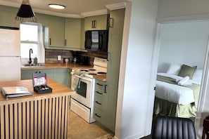 Een kleine keuken met een fornuis, magnetron en koffiezetapparaat.