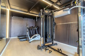 A gym with exercise equipment, treadmills, and a weightlifting station. - W TAMBAU (Joao Pessoa)