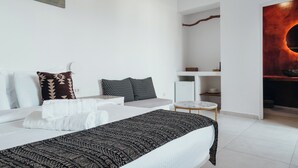 Et moderne hotelværelse med en pænt redt seng, et lille rundt bord og minimalistisk indretning.