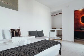 Ein modernes Hotelzimmer mit einem ordentlich bezogenen Bett, einem kleinen runden Tisch und einer minimalistischen Einrichtung.