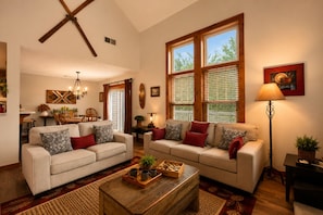A living room with two sofas, a coffee table, and large windows. - Camelback Retreat | Epic Game Room & Fireplace (Tannersville)