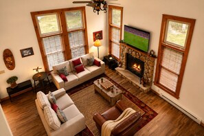 A living room with a fireplace, a television, and a sofa. - Camelback Retreat | Epic Game Room & Fireplace (Tannersville)