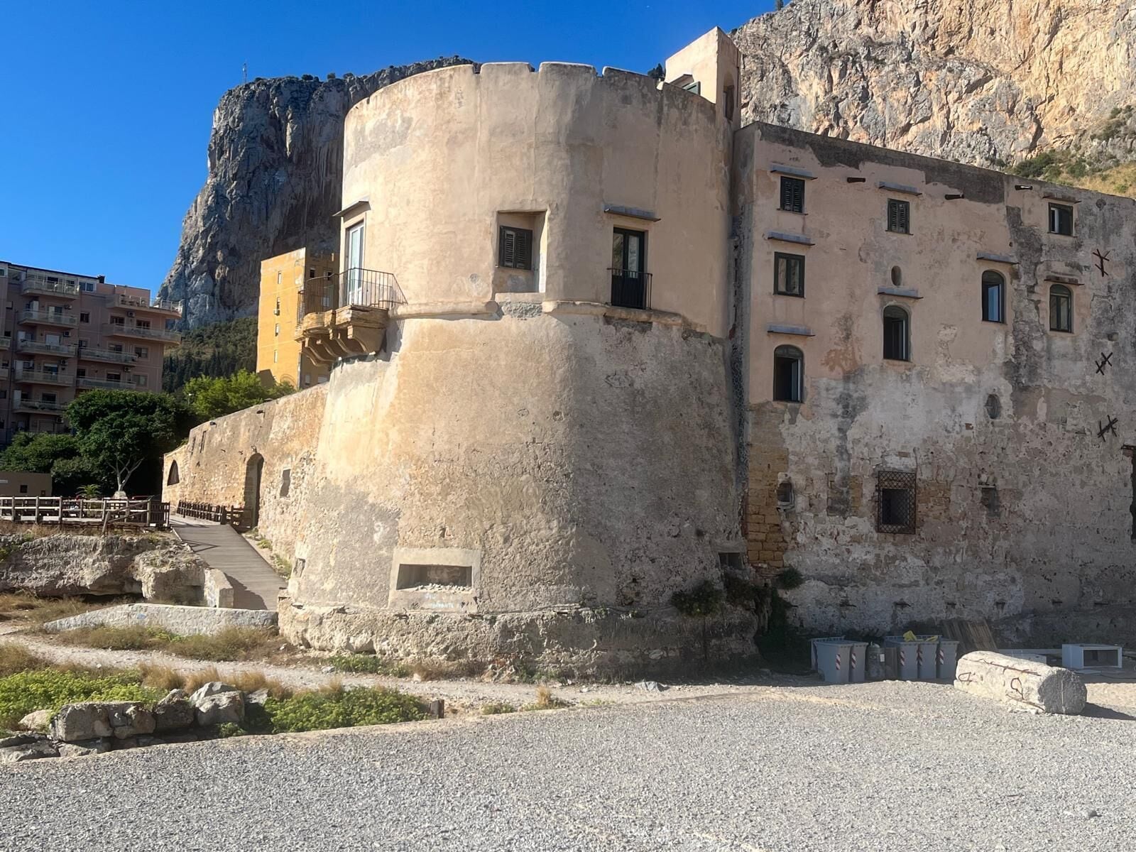 Un edificio storico con una torre circolare, numerose finestre e un balcone.