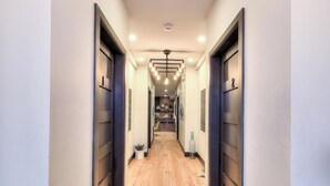 A hallway with wooden flooring, dark doors, and recessed lighting. - Stylish 5BR in Plateau Sleeps 10 (Montreal)