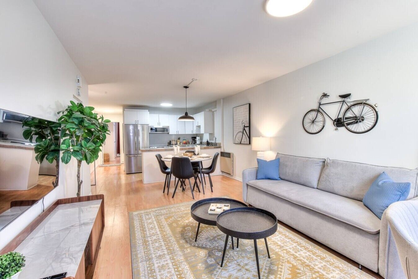 A modern apartment with a dining area, kitchen, and living room.