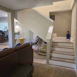 Ein modernes Interieur mit Treppe, einer Couch und einem Essbereich.
