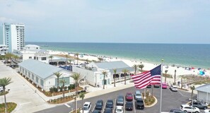 Blick auf einen Strand mit Parkplatz, einem Gebäude und einer US-amerikanischen Flagge.