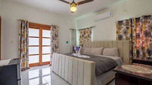Ein Hotelzimmer mit Bett, Deckenventilator, Fernseher und Vorhängen.
