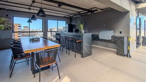 Una cocina moderna con encimera de mármol, taburetes de bar y vistas a la ciudad.