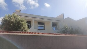 A building with a flat roof, a chimney, and a window.