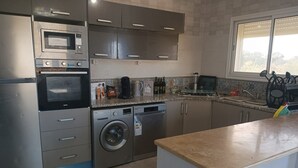 A modern kitchen with stainless steel appliances, a built-in oven, microwave, and dishwasher, and a granite countertop.