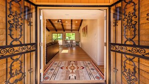 Un couloir avec un tapis à motifs, des murs en bois et un ventilateur de plafond.