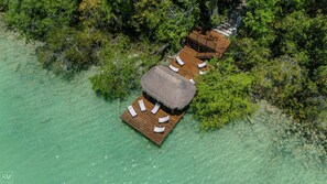 An aerial view of a resort with overwater bungalows connected by walkways, surrounded by clear turquoise water and dense greenery. - Luxury in Bacalar whit Private Dock (Buenavista)