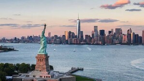 La statue de la Liberté, avec la silhouette d’une ville en arrière-plan.