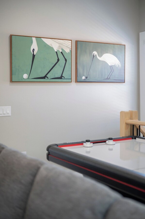 The game room offers entertainment for all ages, with air hockey, comfortable seating, and room to spend time together. - Three Little Birds | Historic Luxury Retreat (Lakeland)