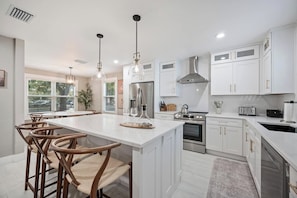 Bright, open kitchen with a spacious island, generous seating, and everything your group needs to cook and gather comfortably. - Three Little Birds | Historic Luxury Retreat (Lakeland)