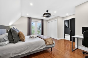 A modern bedroom with a bed, a desk, and a chair.