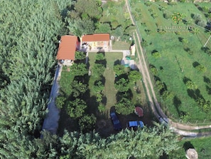 An aerial view of a property with a house, fenced garden, and parked cars. - L'Agrumeto-Casa Cedro. Porto Tramatzu beach (Teulada)