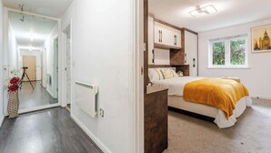 Een slaapkamer met een bed, nachtkastjes, een raam en uitzicht.