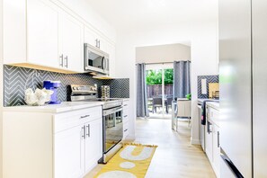 A modern kitchen with white cabinets, a microwave, and a coffee maker. - Bright Contemporary 3BR Home with BBQ & 2-Car Parking (Fremont)