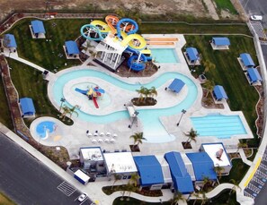 Vista aérea de un parque acuático con múltiples toboganes, piscinas y un estacionamiento.