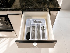 A drawer with utensils neatly organized in compartments. - Skyline Confort Club - Ocean View - SC (Penha)